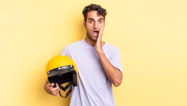 İspanyol yakışıklı adam şok olmuş ve korkmuş hissediyor. Motosiklet kaskı konsepti