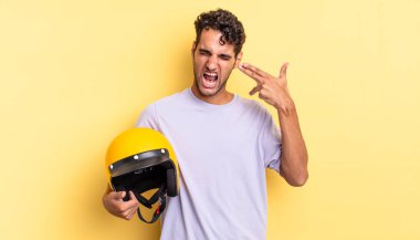 İspanyol yakışıklı adam mutsuz ve stresli görünüyor, intihar jesti silah işareti yapıyor. Motosiklet kaskı konsepti