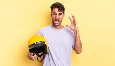 İspanyol yakışıklı adam ellerini havaya kaldırarak bağırıyor. Motosiklet kaskı konsepti