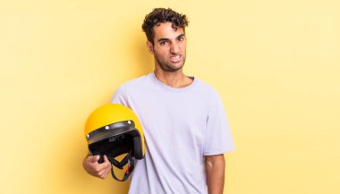 İspanyol yakışıklı adam şaşkın ve şaşkın hissediyor. Motosiklet kaskı konsepti