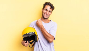 İspanyol yakışıklı adam kendini mutlu hissediyor ve bir meydan okumayla yüzleşiyor ya da kutluyor. Motosiklet kaskı konsepti