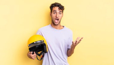 İspanyol yakışıklı adam son derece şaşırmış ve şok olmuş hissediyor. Motosiklet kaskı konsepti