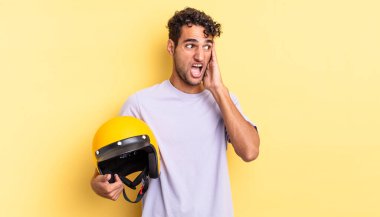 İspanyol yakışıklı adam mutlu, heyecanlı ve şaşırmış hissediyor. Motosiklet kaskı konsepti