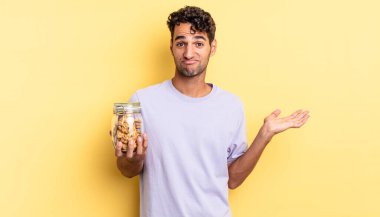 İspanyol yakışıklı adam şaşkın, şaşkın ve şüpheci hissediyor. kurabiye konsepti