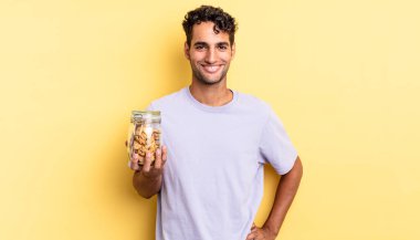 İspanyol yakışıklı adam mutlu bir şekilde gülümsüyor, eli kalçasında ve kendinden emin. kurabiye konsepti