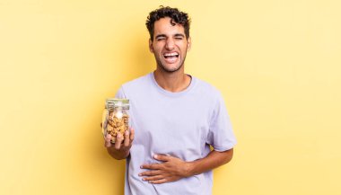 İspanyol yakışıklı bir adam komik bir şakaya yüksek sesle gülüyor. kurabiye konsepti