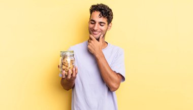 Mutlu, kendine güvenen, elleri çenesinde gülümseyen İspanyol yakışıklı bir adam. kurabiye konsepti