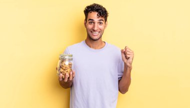 İspanyol yakışıklı adam şokta, gülüyor ve başarıyı kutluyor. kurabiye konsepti