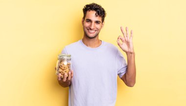 İspanyol yakışıklı adam kendini mutlu hissediyor, iyi bir jestle onaylıyor. kurabiye konsepti