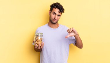 Latin asıllı yakışıklı adam kızgın, baş parmağını kaldırıyor. kurabiye konsepti