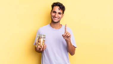 Hispanik yakışıklı adam gururla gülümsüyor ve kendinden emin bir numara oluyor. kurabiye konsepti