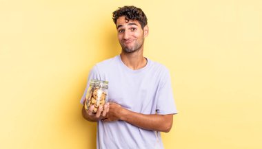 İspanyol yakışıklı adam omuz silkiyor, kafası karışık ve kararsız. kurabiye konsepti