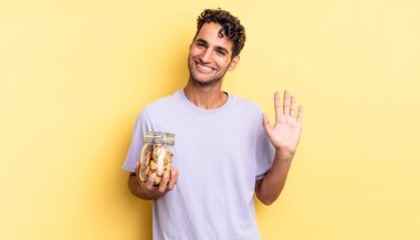 İspanyol yakışıklı adam mutlu bir şekilde gülümsüyor, el sallıyor, seni selamlıyor ve selamlıyor. kurabiye konsepti