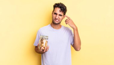 İspanyol yakışıklı adam kafası karışık ve şaşkın hissediyor, senin deli olduğunu gösteriyor. kurabiye konsepti