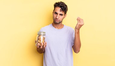 İspanyol yakışıklı adam kapiş ya da para hareketi yapıyor, sana ödemeni söylüyor. kurabiye konsepti