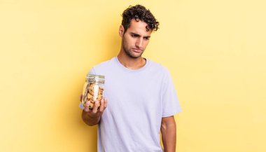 Hispanik yakışıklı adam üzgün, üzgün ya da kızgın hissediyor ve yana bakıyor. kurabiye konsepti