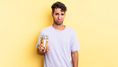 Hispanik yakışıklı adam üzgün ve mızmız, mutsuz bir bakışla ağlıyor. kurabiye konsepti