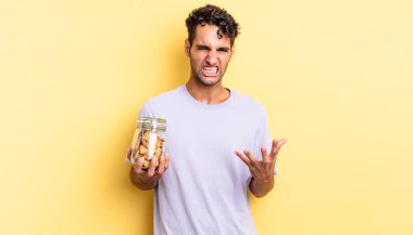 İspanyol yakışıklı adam sinirli, sinirli ve sinirli görünüyor. kurabiye konsepti