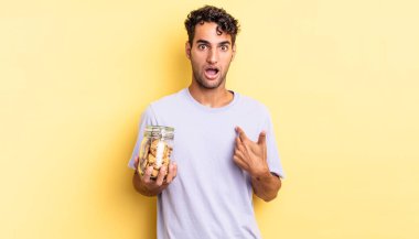 İspanyol yakışıklı adam şok olmuş ve ağzı açık, kendini işaret ederek şaşırmış görünüyor. kurabiye konsepti