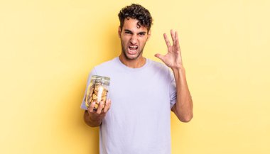 İspanyol yakışıklı adam ellerini havaya kaldırarak bağırıyor. kurabiye konsepti