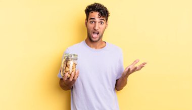 İspanyol yakışıklı adam son derece şaşırmış ve şok olmuş hissediyor. kurabiye konsepti