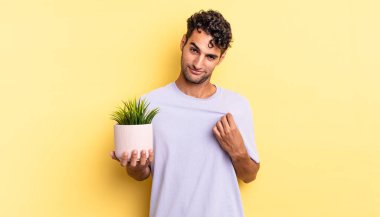 İspanyol yakışıklı adam kibirli, başarılı, pozitif ve gururlu görünüyor. dekoratif bitki konsepti