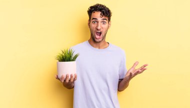 İspanyol yakışıklı adam inanılmaz bir sürprizle şaşkına dönmüş ve hayrete düşmüştü. dekoratif bitki konsepti