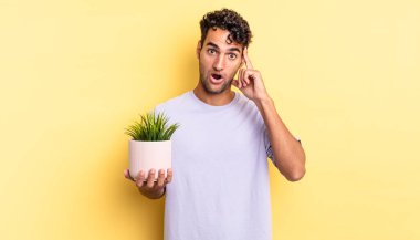 İspanyol yakışıklı adam şaşırmış görünüyor, yeni bir düşünce, fikir ya da konsept fark ediyor. dekoratif bitki konsepti