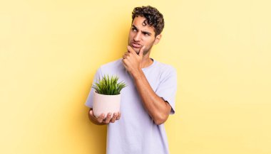 İspanyol yakışıklı düşünen, kuşkucu ve kafası karışık bir adam. dekoratif bitki konsepti