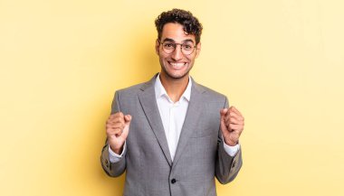 İspanyol yakışıklı adam şokta, gülüyor ve başarıyı kutluyor. iş kavramı