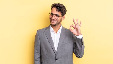 İspanyol yakışıklı adam kendini mutlu hissediyor, iyi bir jestle onaylıyor. iş kavramı