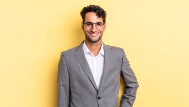 İspanyol yakışıklı adam mutlu bir şekilde gülümsüyor, eli kalçasında ve kendinden emin. iş kavramı