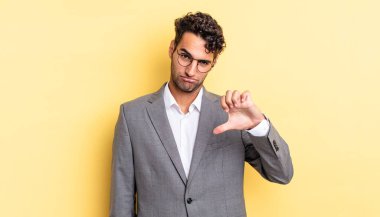 Latin asıllı yakışıklı adam kızgın, baş parmağını kaldırıyor. iş kavramı