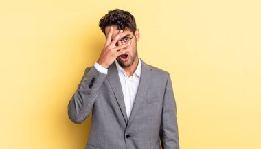 İspanyol yakışıklı adam şok olmuş, korkmuş ya da korkmuş görünüyor. Yüzü elle kapatılmış. iş kavramı