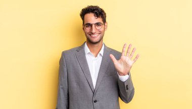 İspanyol yakışıklı adam gülümsüyor ve arkadaş canlısı görünüyor, beş numarayı gösteriyor. iş kavramı