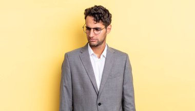 Hispanik yakışıklı adam üzgün, üzgün ya da kızgın hissediyor ve yana bakıyor. iş kavramı