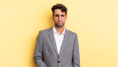 Hispanik yakışıklı adam üzgün ve mızmız, mutsuz bir bakışla ağlıyor. iş kavramı