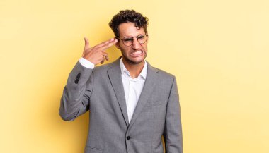 İspanyol yakışıklı adam mutsuz ve stresli görünüyor, intihar jesti silah işareti yapıyor. iş kavramı