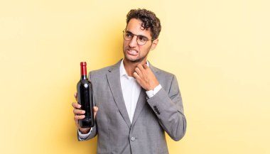 İspanyol yakışıklı adam stresli, endişeli, yorgun ve hayal kırıklığına uğramış hissediyor. şarap şişesi konsepti