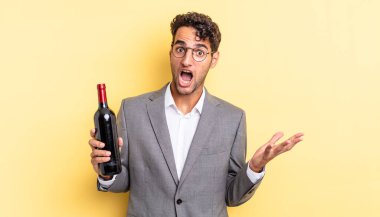 İspanyol yakışıklı adam inanılmaz bir sürprizle şaşkına dönmüş ve hayrete düşmüştü. şarap şişesi konsepti