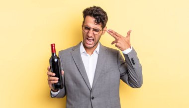 İspanyol yakışıklı adam mutsuz ve stresli görünüyor, intihar jesti silah işareti yapıyor. şarap şişesi konsepti