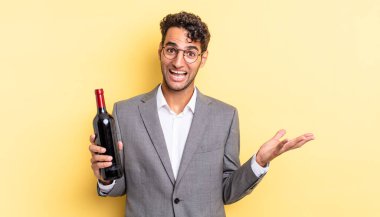 İspanyol yakışıklı adam kendini mutlu hissediyor, bir çözüm ya da fikir bulduğuna şaşırıyor. şarap şişesi konsepti