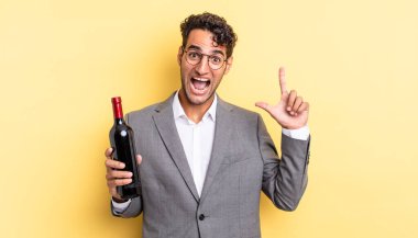 İspanyol yakışıklı bir adam bir fikri fark ettikten sonra mutlu ve heyecanlı bir dahi gibi hissediyor. şarap şişesi konsepti