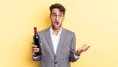 İspanyol yakışıklı adam son derece şaşırmış ve şok olmuş hissediyor. şarap şişesi konsepti