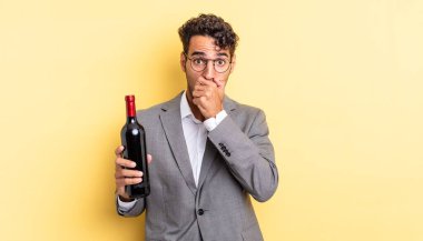 İspanyol yakışıklı adam şok olmuş bir şekilde ağzını kapatıyor. şarap şişesi konsepti
