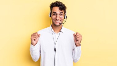 İspanyol yakışıklı adam şokta, gülüyor ve başarıyı kutluyor. tele pazarlamacı konsepti