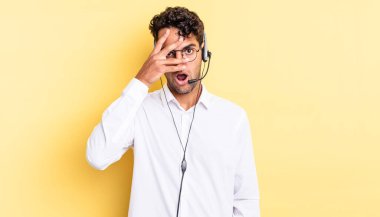 İspanyol yakışıklı adam şok olmuş, korkmuş ya da korkmuş görünüyor. Yüzü elle kapatılmış. tele pazarlamacı konsepti