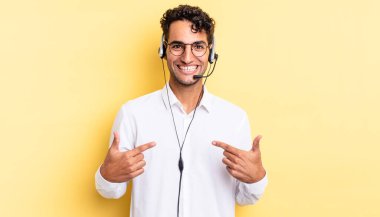 İspanyol yakışıklı adam mutlu hissediyor ve heyecanla kendini işaret ediyor. tele pazarlamacı konsepti