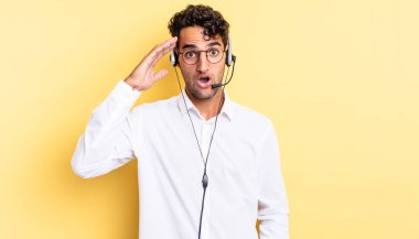 İspanyol yakışıklı adam mutlu, şaşkın ve şaşırmış görünüyor. tele pazarlamacı konsepti