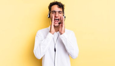 İspanyol yakışıklı adam kendini mutlu hissediyor, elleri ağızının yanında bağırıyor. tele pazarlamacı konsepti